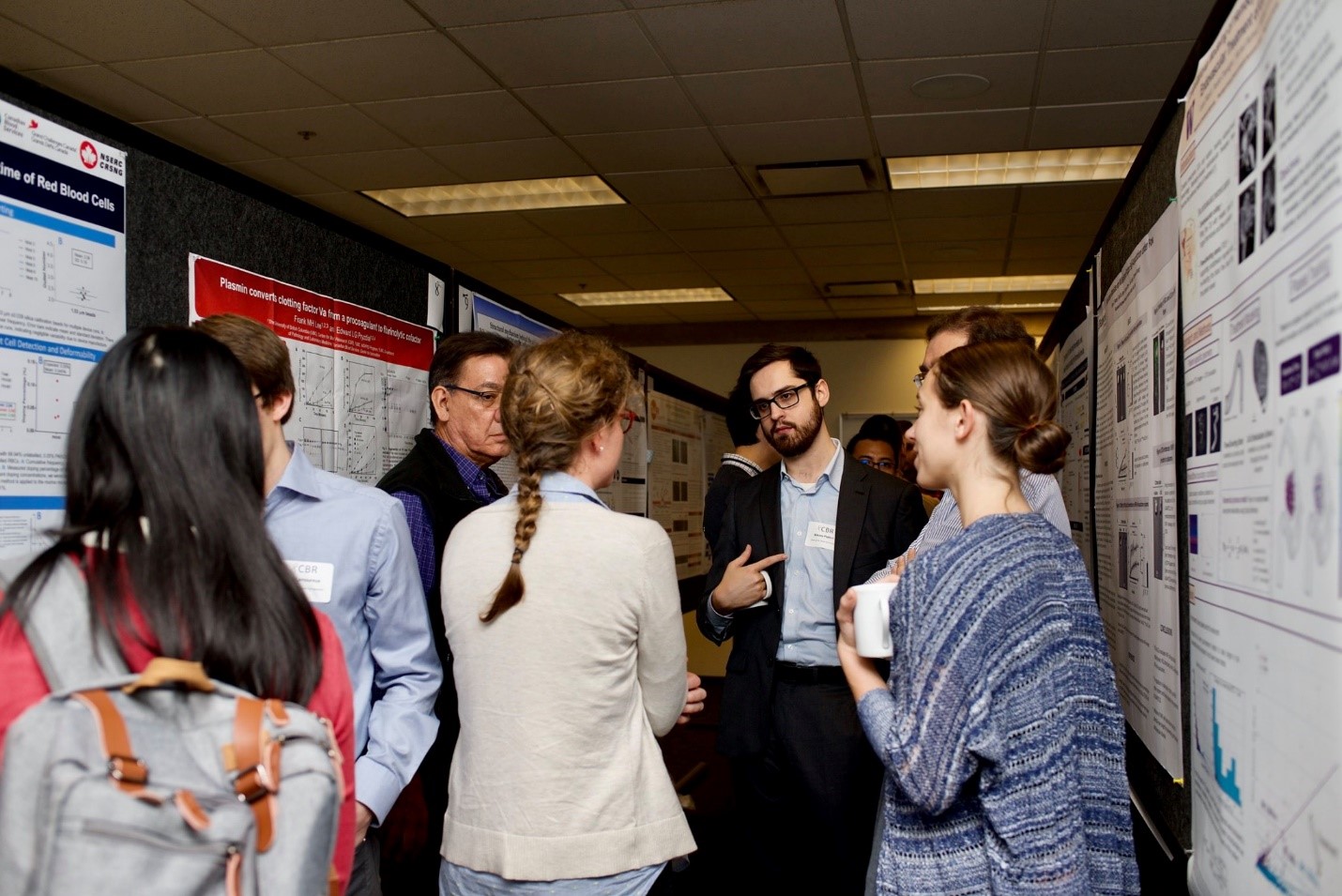 ttendees discuss posters during the 13th annual Earl W. Davie Symposium.