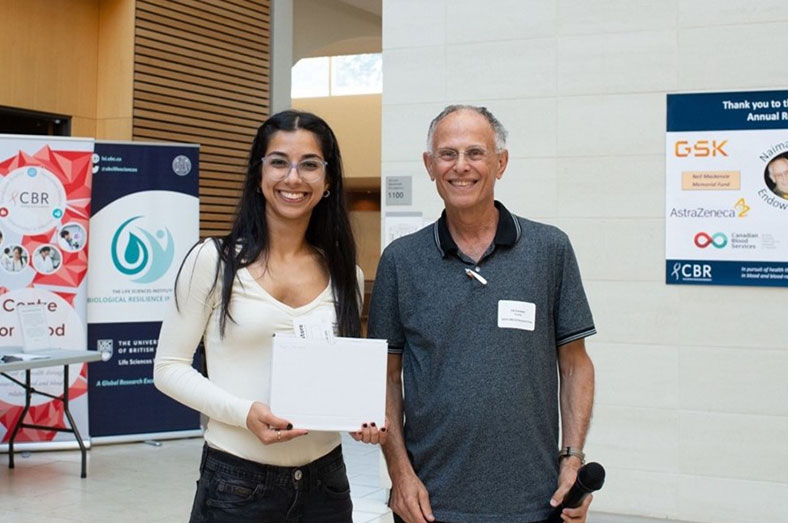 Dr. Ed Conway holding an award with Houria Afshar Moghaddam