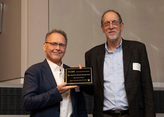 Two people holding an black plaque award