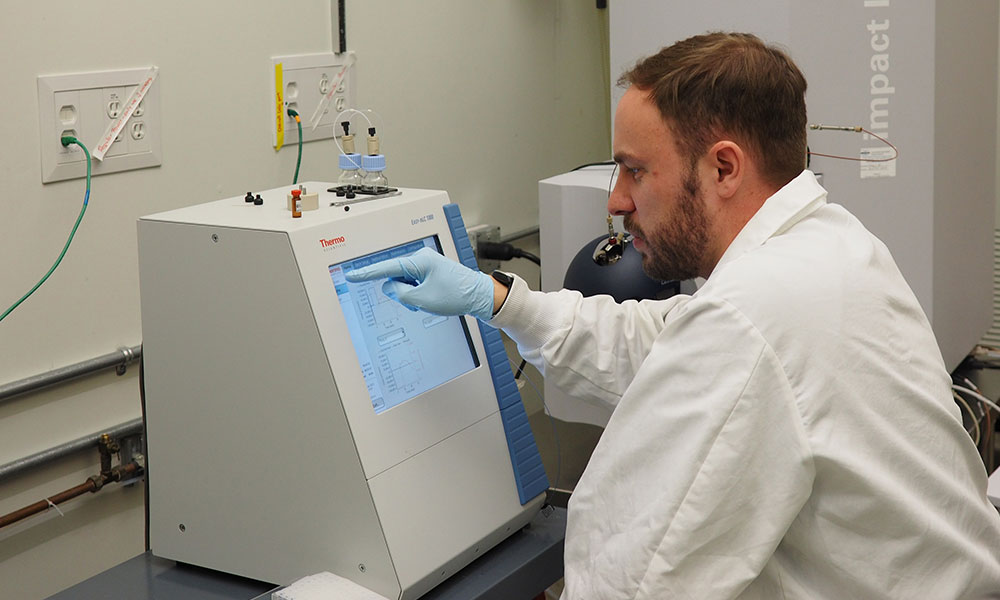 Research associate pointing to a screen in a lab