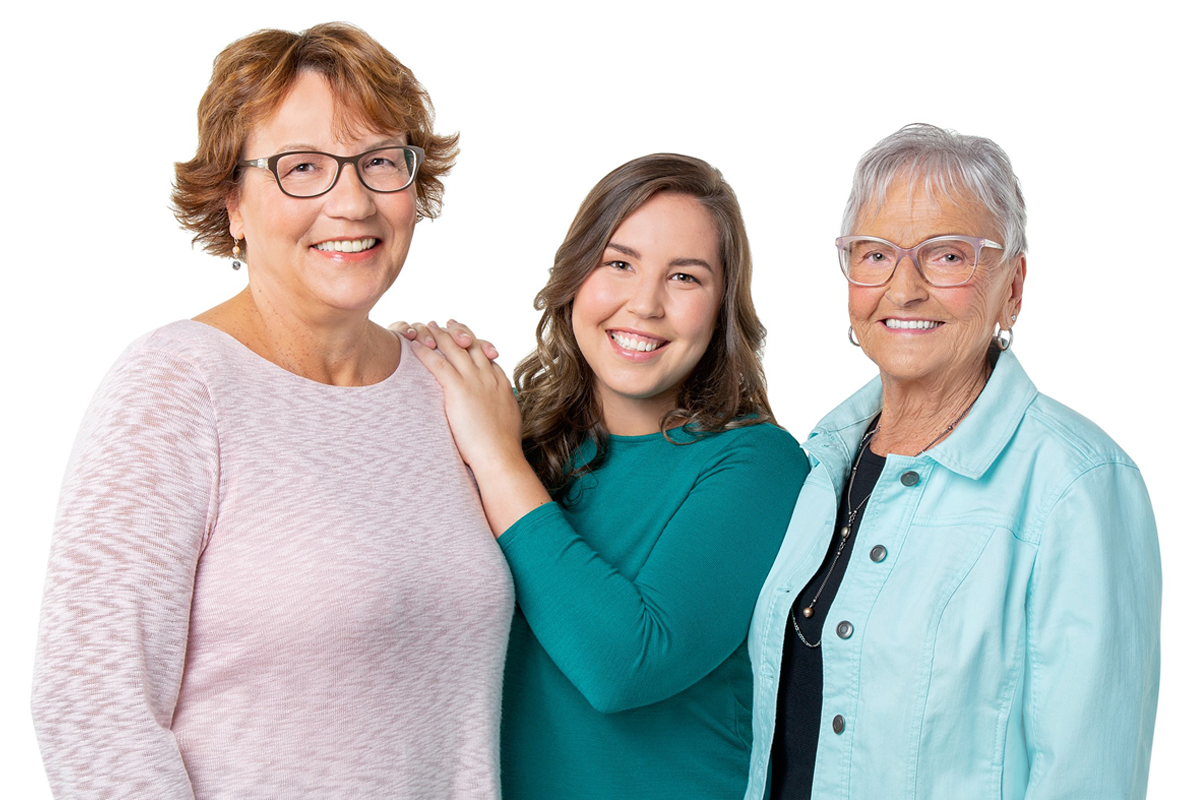 An young adult woman standing between her mother and grandmother
