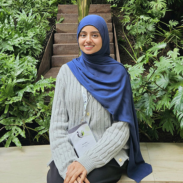 Sonia Mirza sitting in front of steps and plants behind her