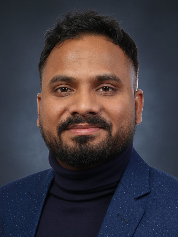 Close-up portrait of Saifur Chowdhury, wearing a black turtleneck and a navy blazer.
