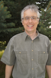 Man in short sleeved shirt poses for photo