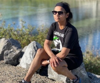 Stem cell recipient sitting outdoors on a rock near water