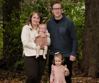 Parents, young daughter and infant daughter outdoors