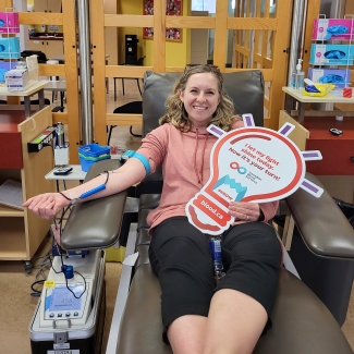 Blood donor in bed with Shine A Light sign