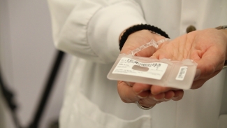 Image of a lab technician cupping an empty unit in between their hands