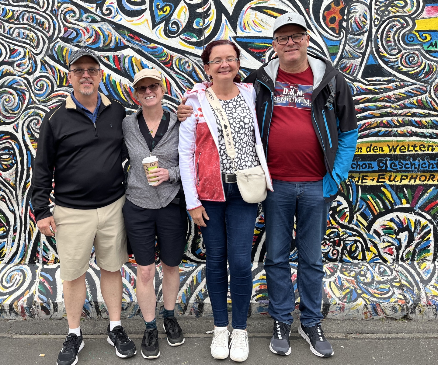 Two couples in front of Berlin Wall