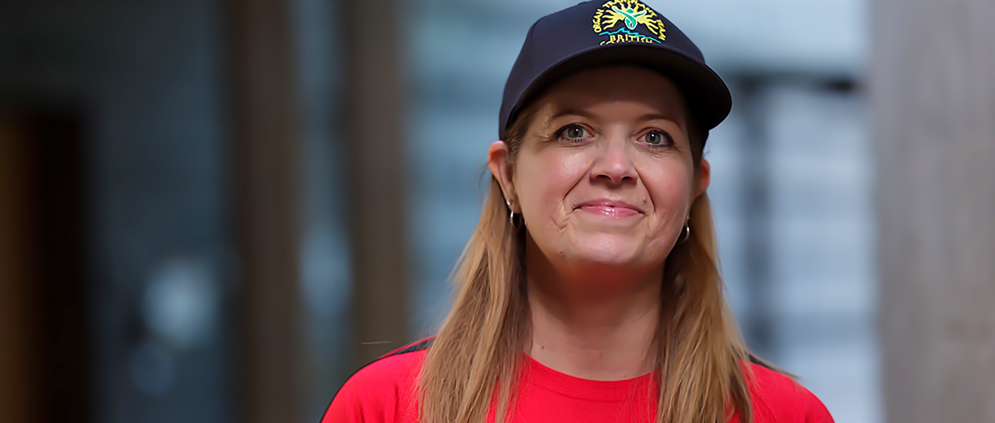 Featured image of Brenda Brown wearing a hat smiling in front of window.