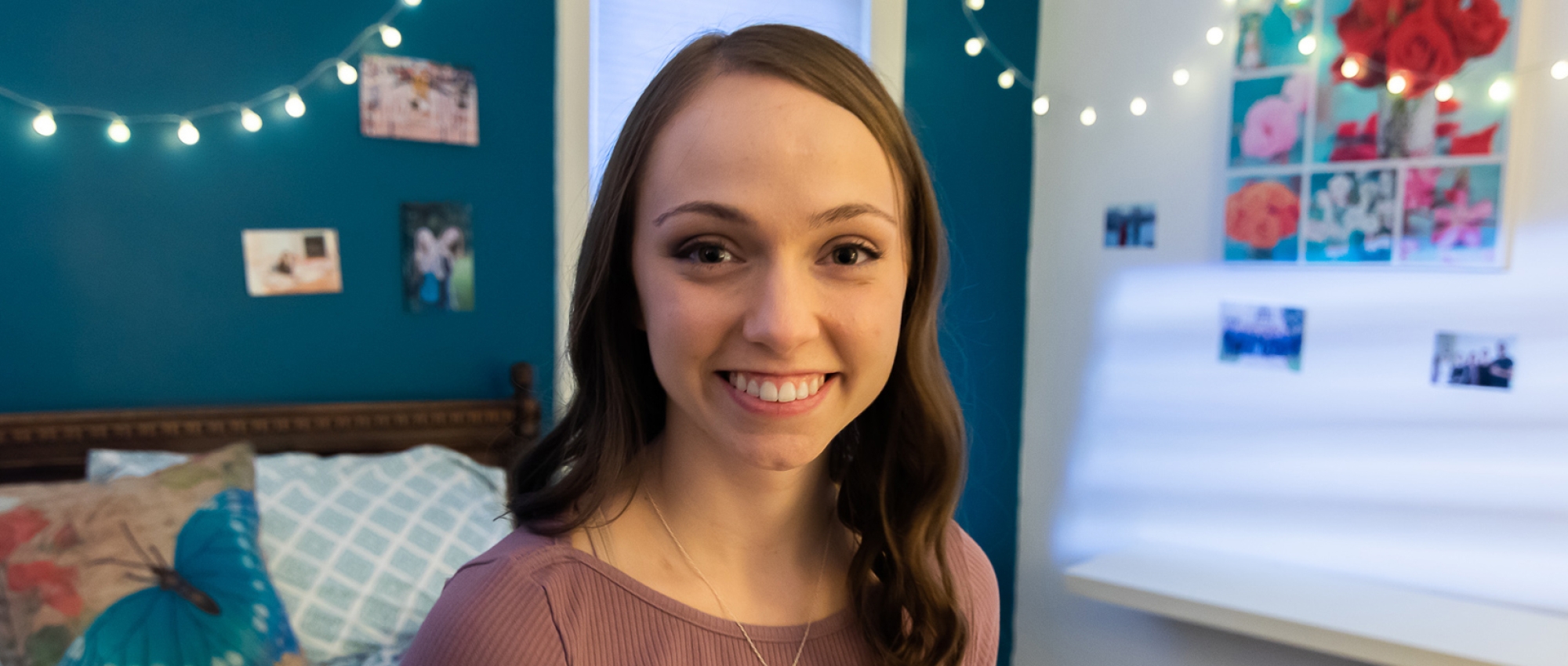 Image of Mackenzie Curran sitting on her bed in her bedroom