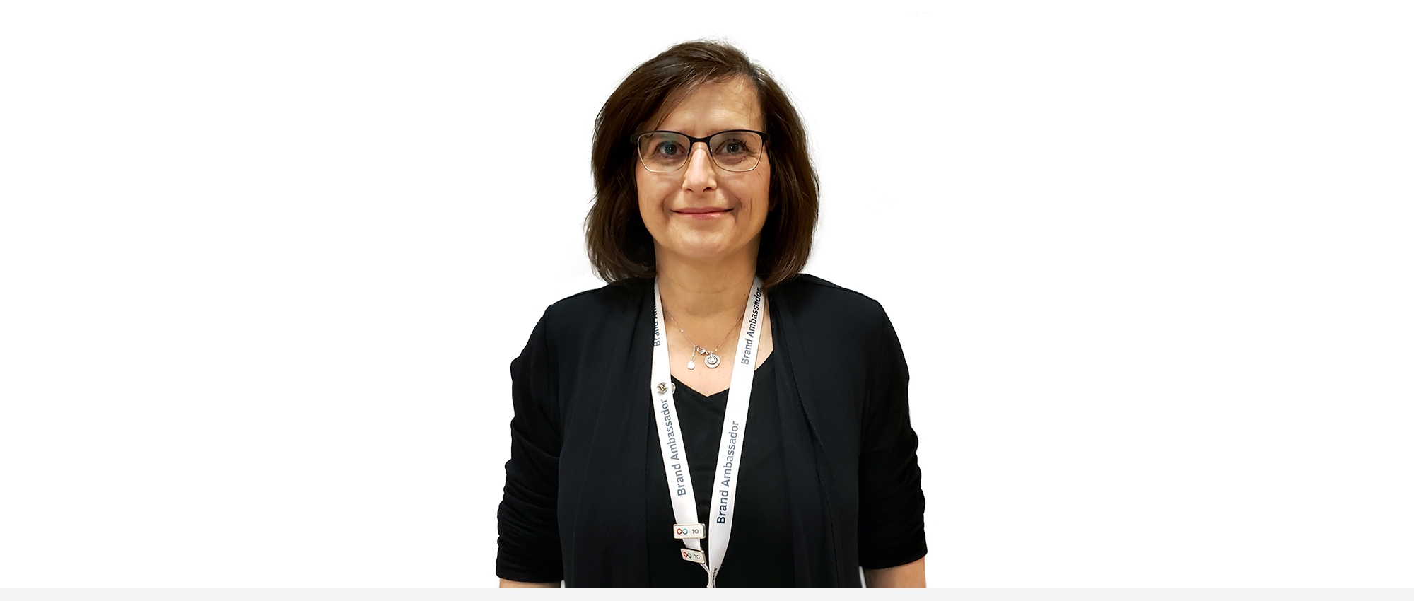 A woman with short brown hair and glasses wearing a Canadian Blood Services Brand Ambassador lanyard around her neck.