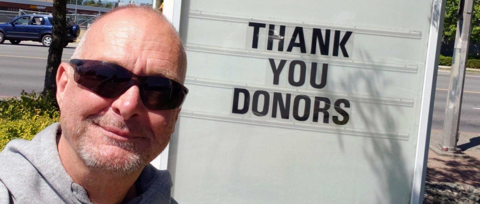 Man in front of sign