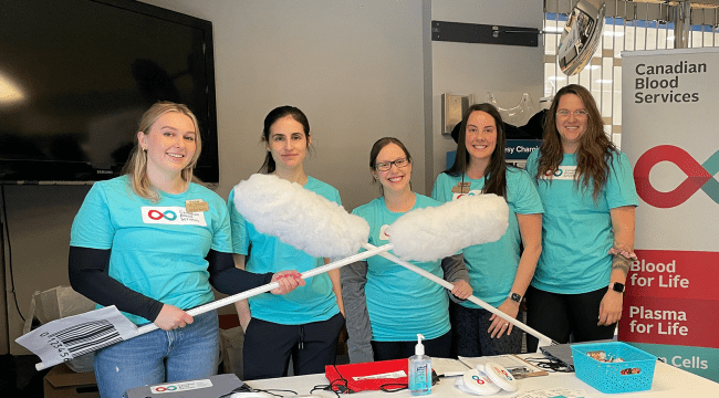 Group of students holding two giant swabs 