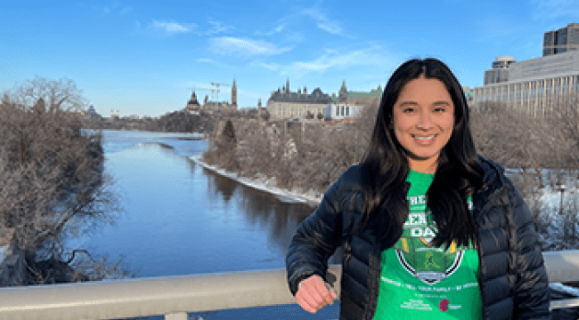 A woman in a green shirt stands on a bridge in Ottawa 