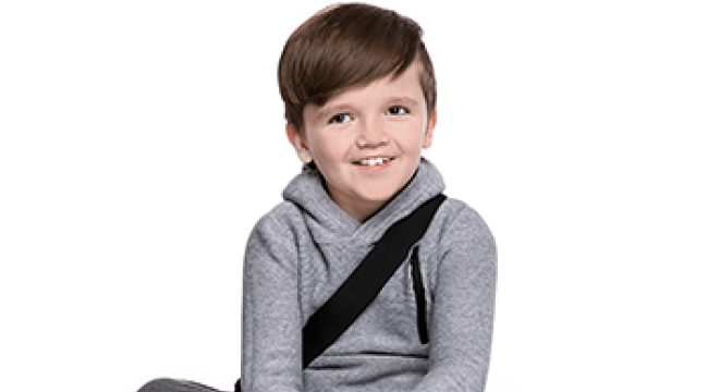 A child sitting cross-legged, smiling