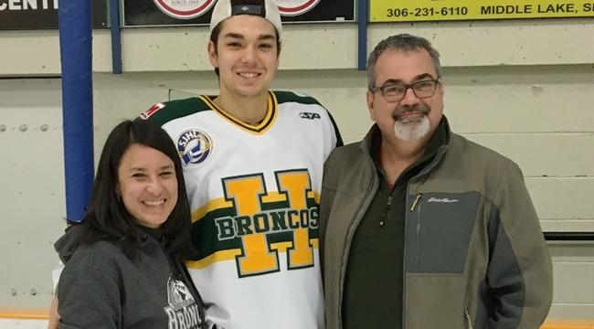 Logan Boulet with his parents Toby and Bernadine Boulet inside a hockey arena