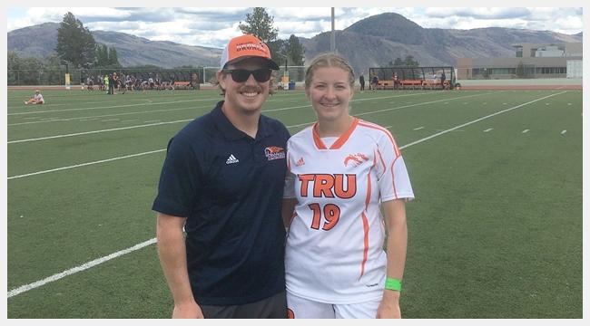 Kamloops Broncos Football Club head coach Braden Vankoughnett stands on a field beside his girlfriend Kelsey Thorkelsson, who has aplastic anemia and needs regular blood transfusions.