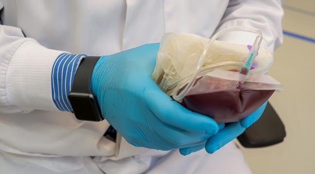 Person wearing gloves holding the blood bag