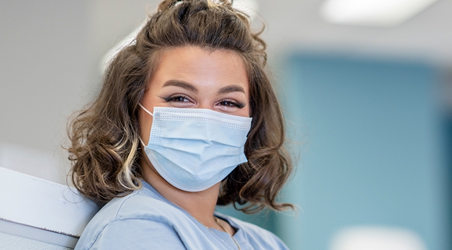 a smiling blood donor wearing a mask